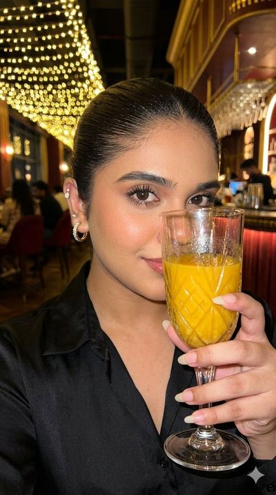 A woman holds red wine glass in a luxurious bar setting