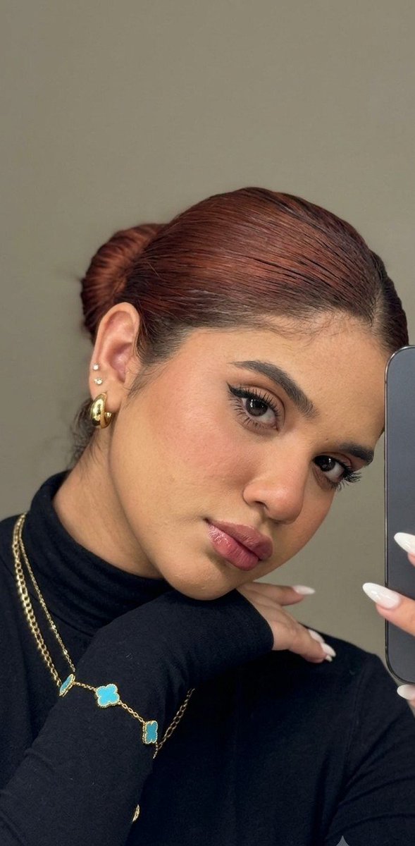 A young girl captures a moody mirror selfie with layered hair