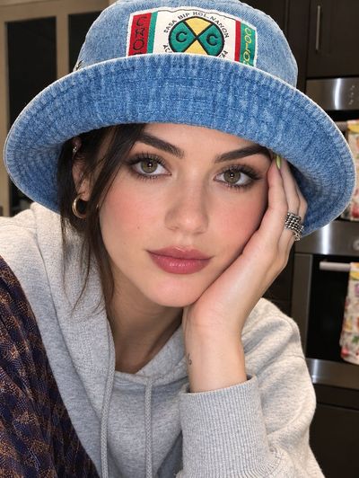 Young Woman in Denim Bucket Hat Poses in Modern Kitchen Light