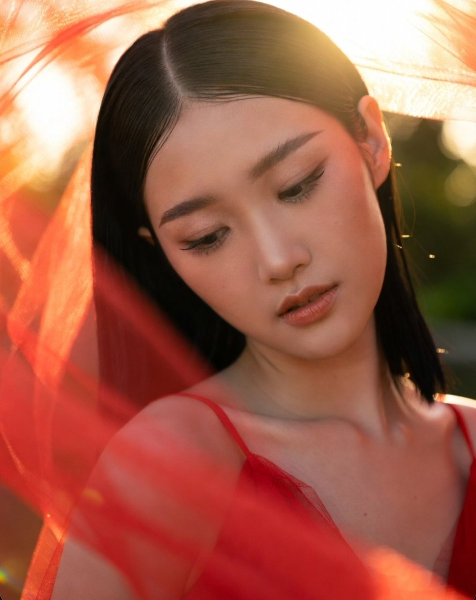 Golden sunset glow illuminates serene woman in red haze