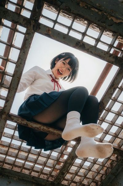 Industrial Contrast: Low-Angle Portrait of Joyful Woman Through Rusted Grate