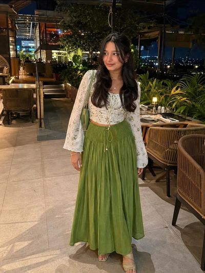 White floral crop top pairs with olive green maxi skirt
