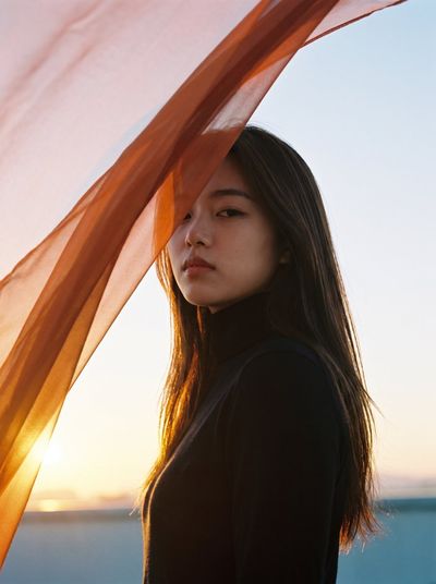 Dusk silhouette glows with translucent orange fabric over face