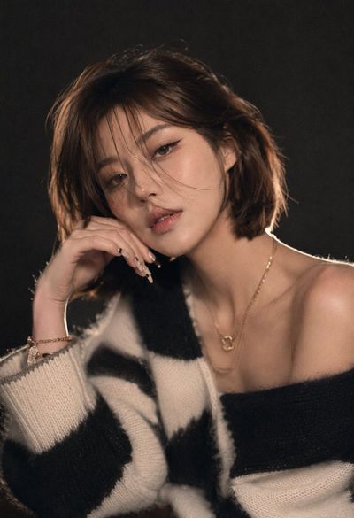 Young woman in oversized sweater gazes softly in studio light