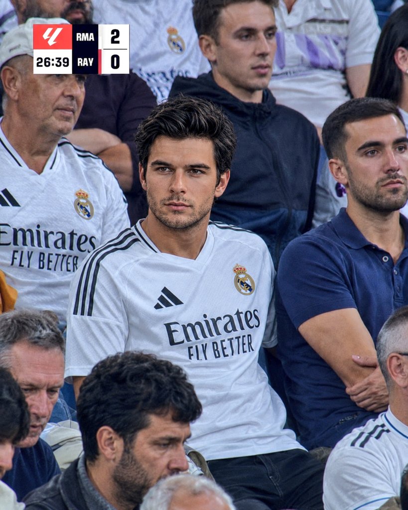 A devoted Real Madrid fan watches intensely from the packed stands.
