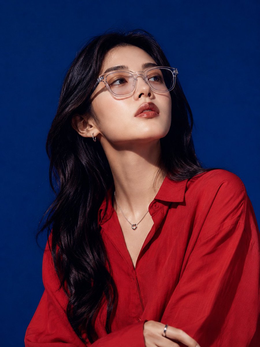 East Asian model poses in red silk against royal blue backdrop