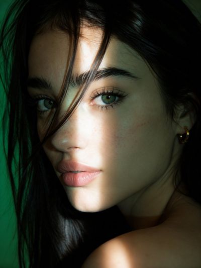 Emerald gaze meets warm sunlight in moody editorial portrait
