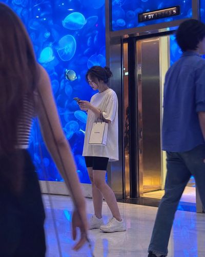 A shopper's quiet moment with jellyfish in a luxury mall