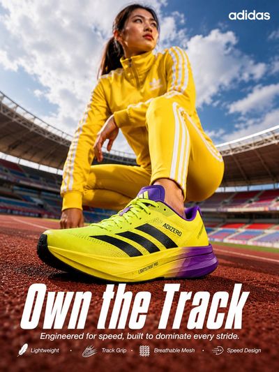 Young Asian athlete crouches on track with yellow Adidas shoe