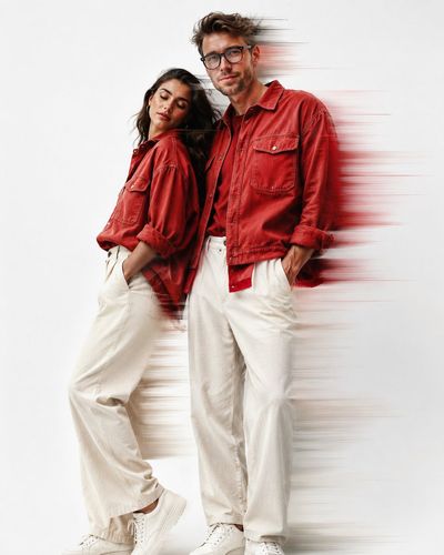 Red denim shirt couple stands in bright studio with motion blur