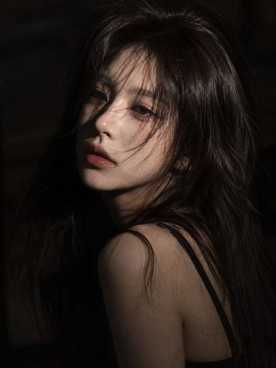 Melancholic woman with dark hair gazes softly in cinematic light