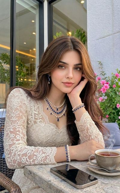 Young woman with flowing brown hair rests at outdoor café