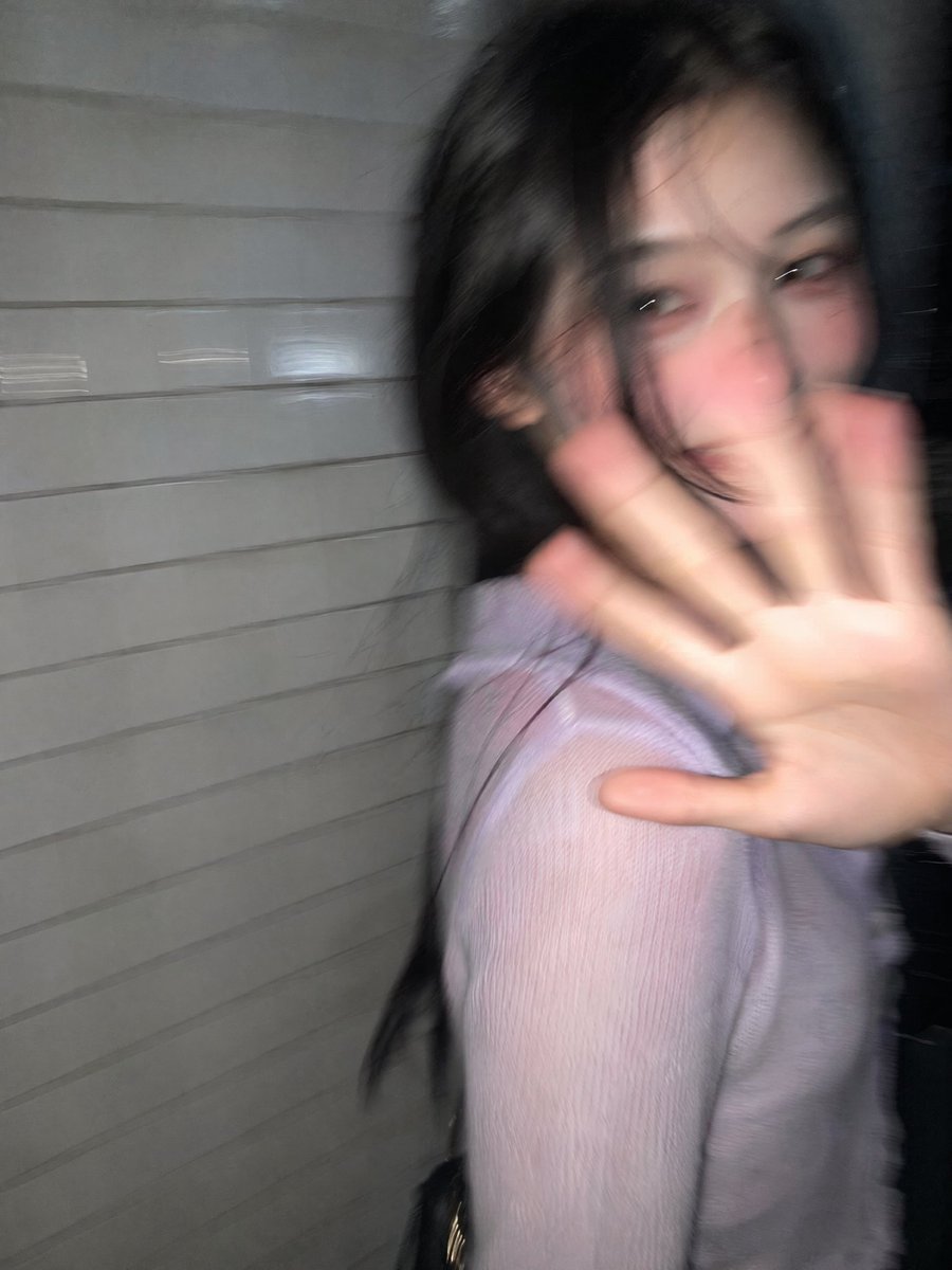 A young woman turns in surprise on a dark Tokyo street