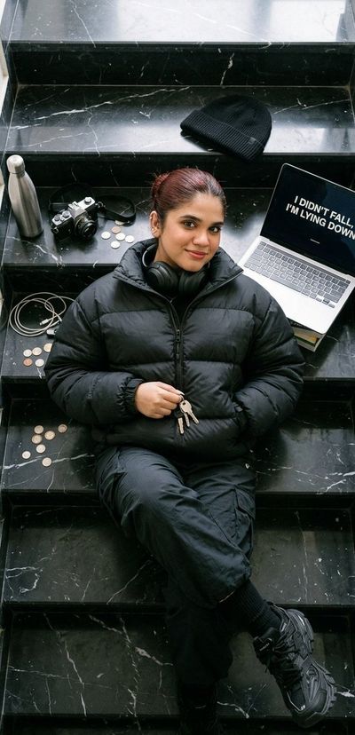 Woman lies across black marble steps with open laptop