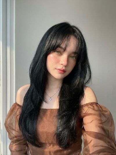 Soft morning light illuminates a young woman's serene portrait indoors