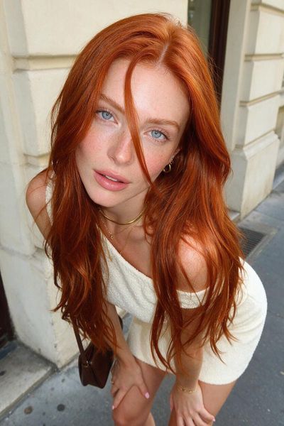 Copper-haired woman gazes upward in high-angle street portrait