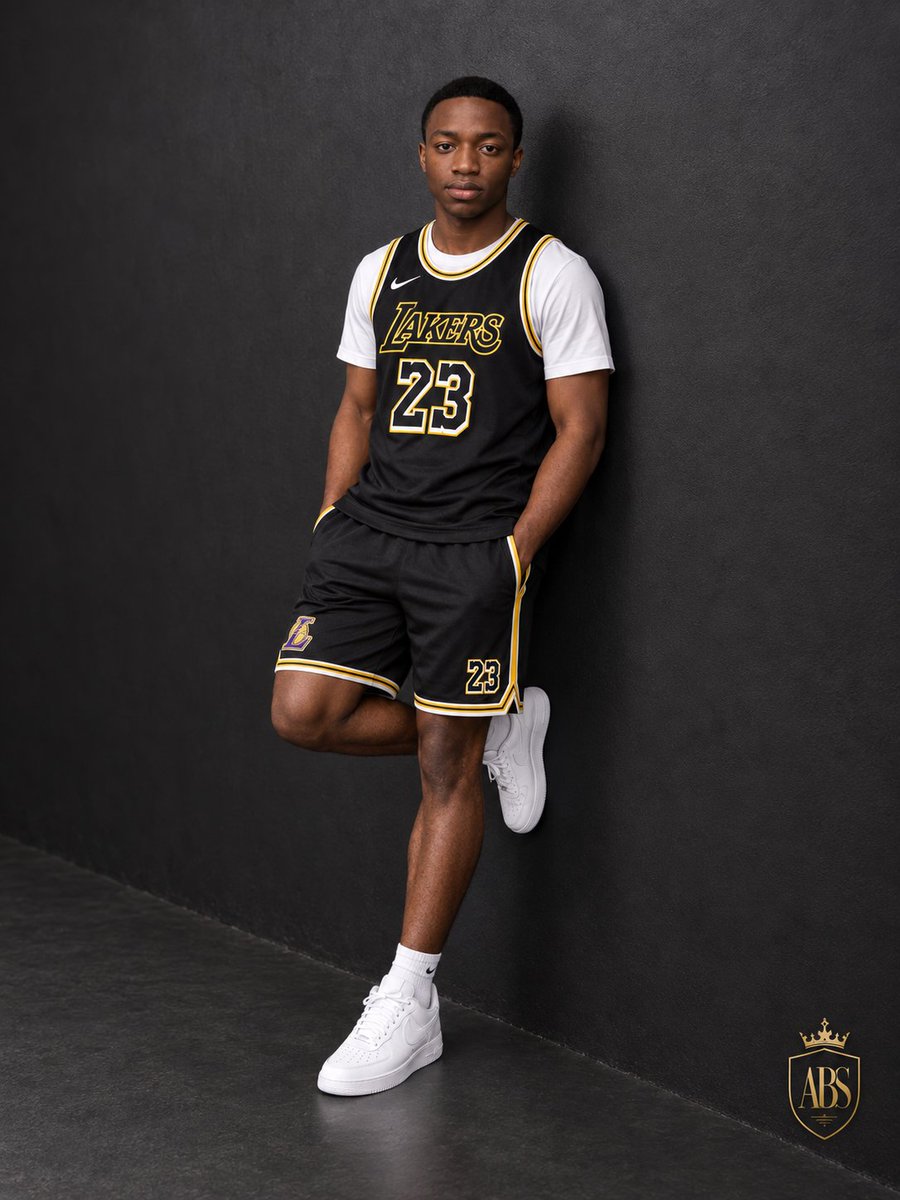Confident Man Leans on Charcoal Wall in Lakers Jersey