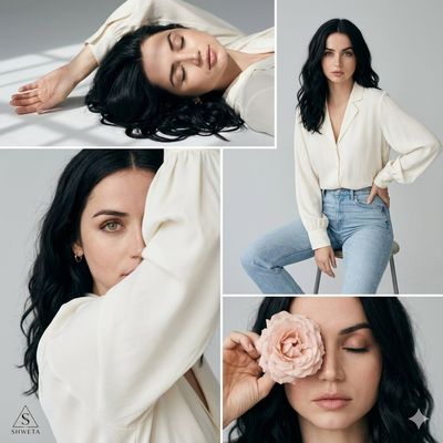 Woman in ivory blouse lies gracefully on gray studio floor