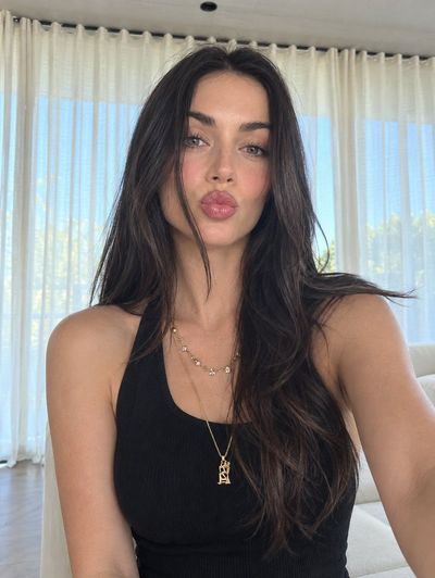 Young woman takes a close-up selfie in bright modern living room