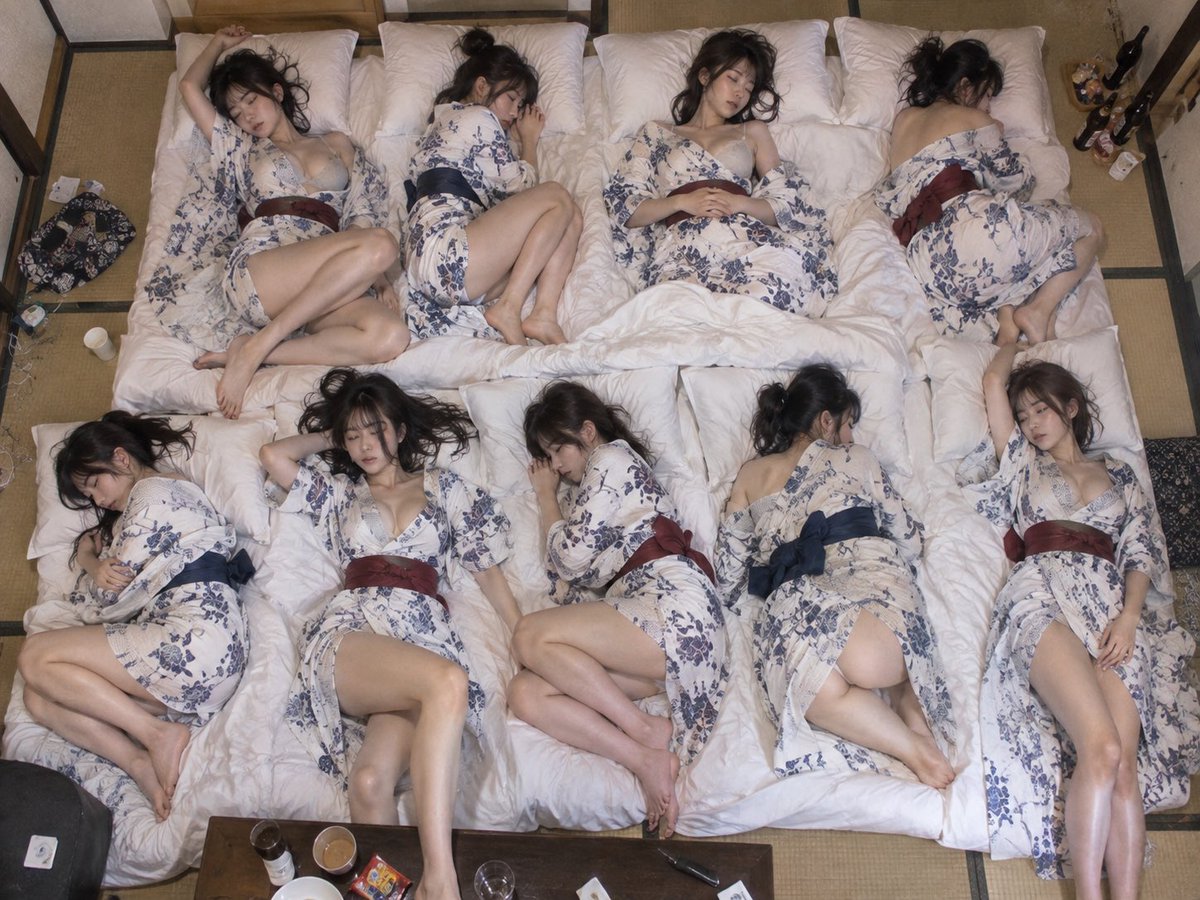 Overhead shot of nine women sleeping on futons in a ryokan