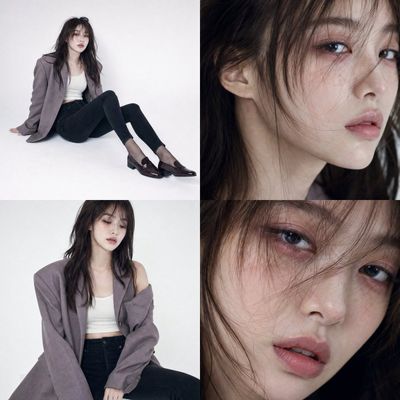 Female model in oversized blazer sits coldly on white studio floor