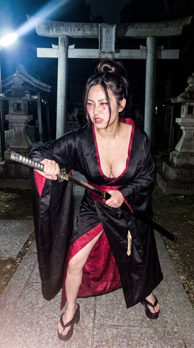 Yuna grips a katana under a harsh Xenon flash in Kyoto