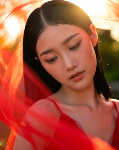 Golden sunset glow illuminates serene woman in red haze