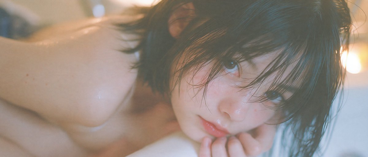 Woman curled in dry bathtub against vivid purple void
