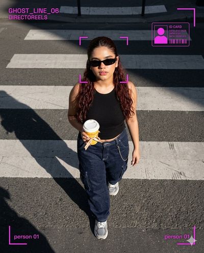 Woman with coffee crosses Parisian zebra crossing under morning sun