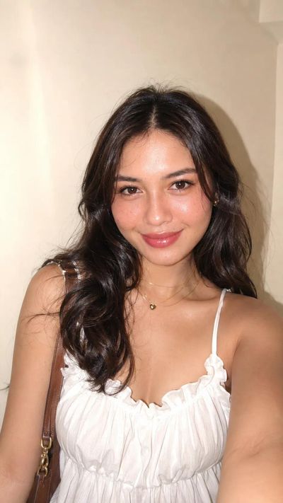 A young woman poses with a soft glamorous flash portrait style