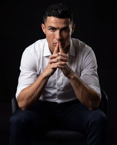 A man leans forward with interlocked fingers in intense thought