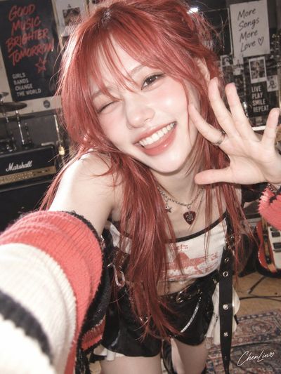 Coral-red haired girl grins in close-up Y2K magazine selfie style