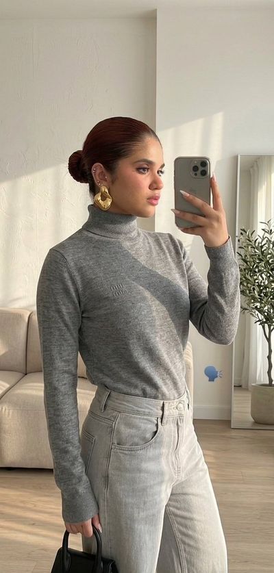 A girl captures a mirror selfie in soft morning light