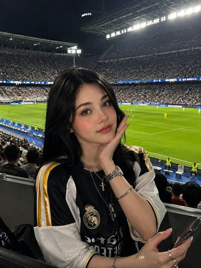 Korean fan girl poses at night football match in packed stadium