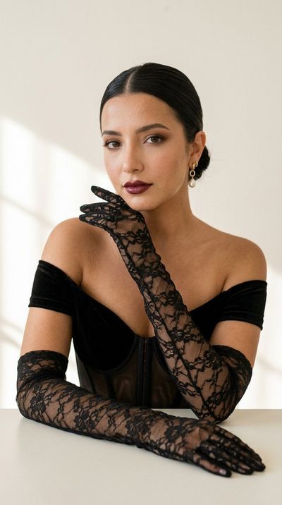 A sophisticated woman in black velvet poses with lace gloves