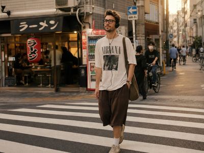 A solitary man crosses a sunlit street in a quiet Tokyo neighborhood