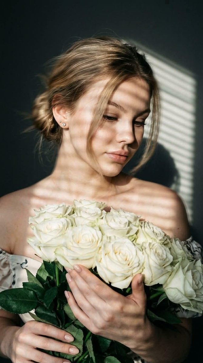Woman with white roses in striped light, hair blurred