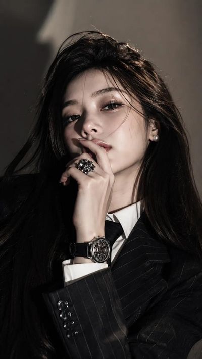 Mysterious woman in striped suit with hand near glossy lips